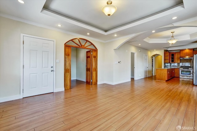 2486 26th Ave, Oakland, CA 94601 - unfurnished living room with a raised ceiling, arched walkways, light wood finished floors, recessed lighting, and crown molding