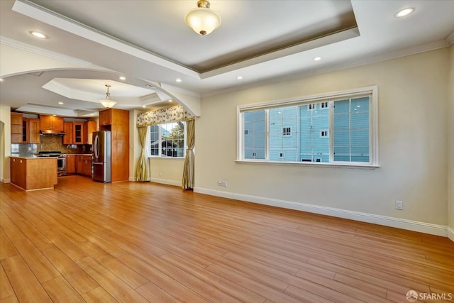 2486 26th Ave, Oakland, CA 94601 - unfurnished living room featuring a raised ceiling, arched walkways, light wood-style floors, crown molding, and recessed lighting