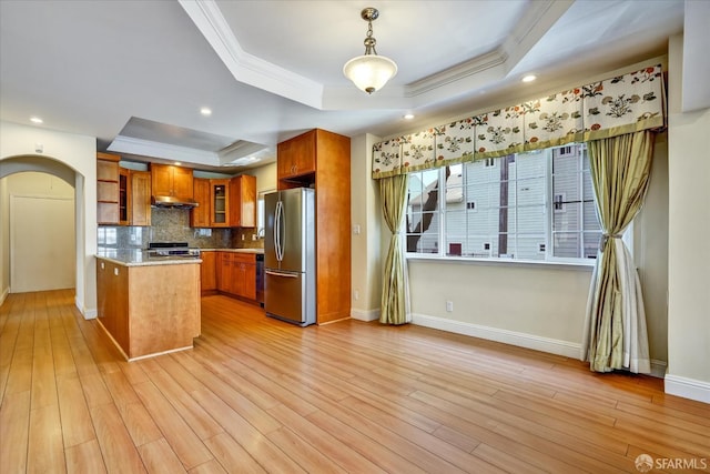 2486 26th Ave, Oakland, CA 94601 - kitchen featuring appliances with stainless steel finishes, a raised ceiling, brown cabinets, crown molding, and arched walkways
