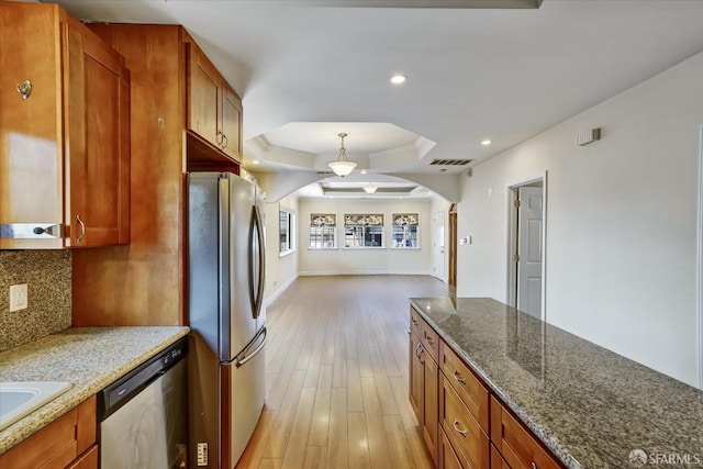 2486 26th Ave, Oakland, CA 94601 - kitchen with appliances with stainless steel finishes, a tray ceiling, arched walkways, backsplash, and light wood-style flooring