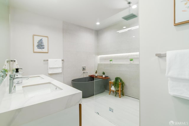 bathroom featuring vanity, separate shower and tub, tile patterned flooring, and tile walls