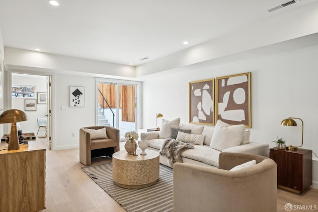 living area featuring light wood-type flooring, recessed lighting, and baseboards