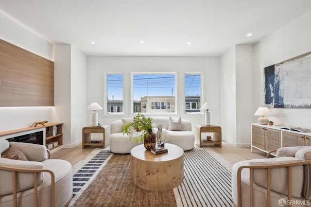 living area featuring light wood-type flooring, recessed lighting, and baseboards
