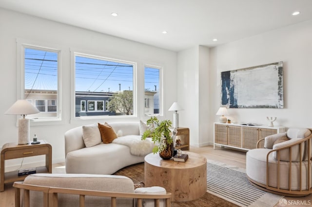 living area featuring recessed lighting, baseboards, and light wood-style flooring