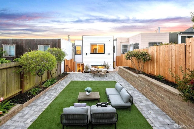 back of property at dusk featuring a patio area and outdoor lounge area