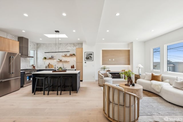 living room with recessed lighting, light wood-type flooring, and a skylight