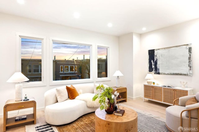 living room with wood finished floors, baseboards, and recessed lighting