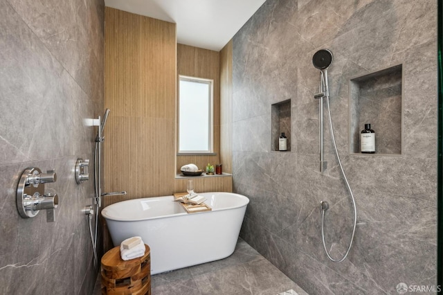 full bathroom featuring a tile shower, a soaking tub, and tile walls