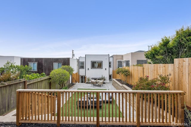 back of property with a fenced backyard and a patio area