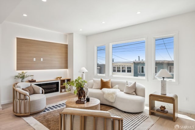 living area with wood finished floors, baseboards, and recessed lighting