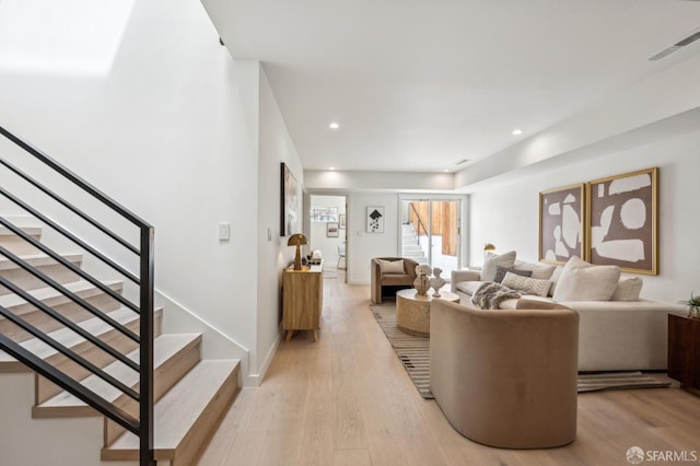 living room featuring stairs, light wood-style floors, and recessed lighting