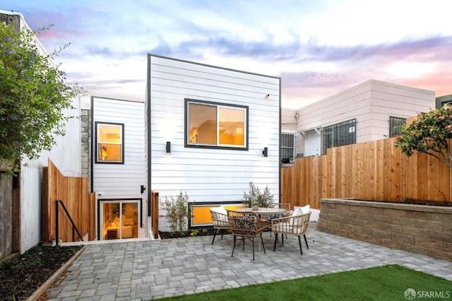 rear view of property featuring a patio area and fence