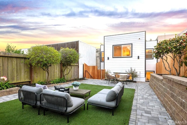 back of house at dusk with a patio area and a fenced backyard