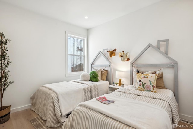 bedroom featuring baseboards, wood finished floors, and recessed lighting