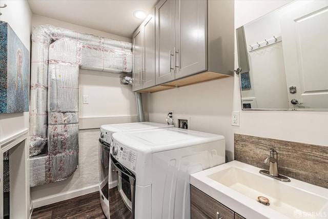 laundry area featuring sink, dark wood-type flooring, cabinets, and independent washer and dryer