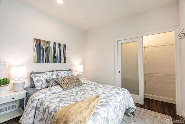 bedroom with dark hardwood / wood-style flooring and a closet