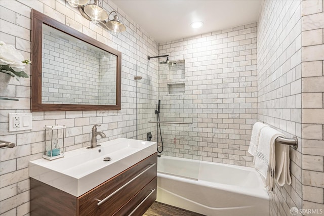 bathroom featuring vanity, tile walls, and tiled shower / bath