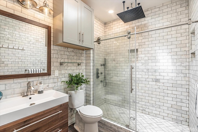 bathroom featuring walk in shower, toilet, vanity, and decorative backsplash