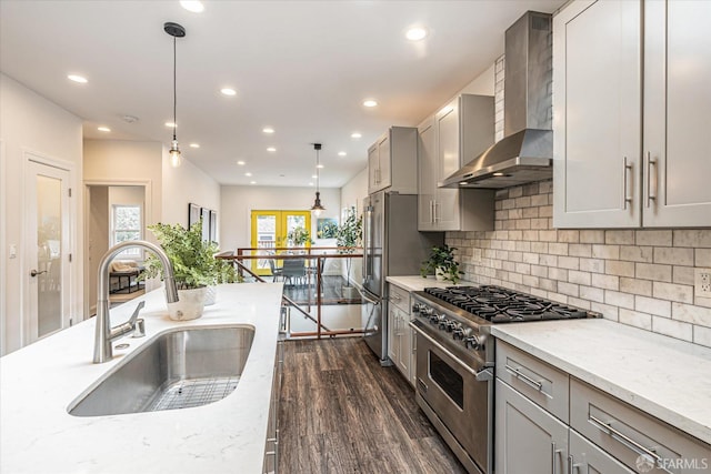 kitchen featuring sink, gray cabinetry, hanging light fixtures, high quality appliances, and wall chimney exhaust hood