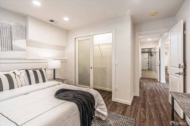 bedroom with dark wood-type flooring and a closet