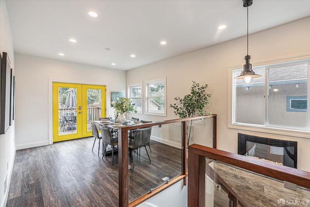 dining room featuring dark hardwood / wood-style flooring, a fireplace, a wealth of natural light, and french doors