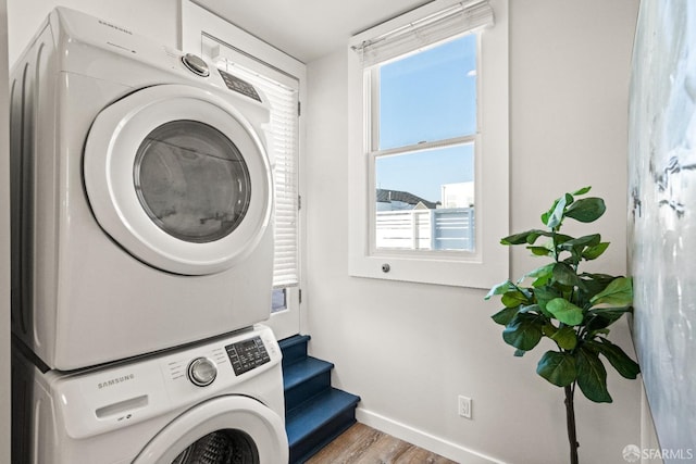 washroom featuring stacked washer and dryer and light wood-type flooring