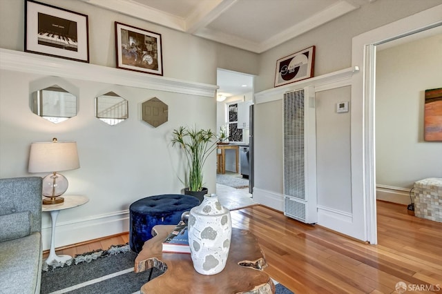 interior space featuring beamed ceiling, crown molding, and hardwood / wood-style floors