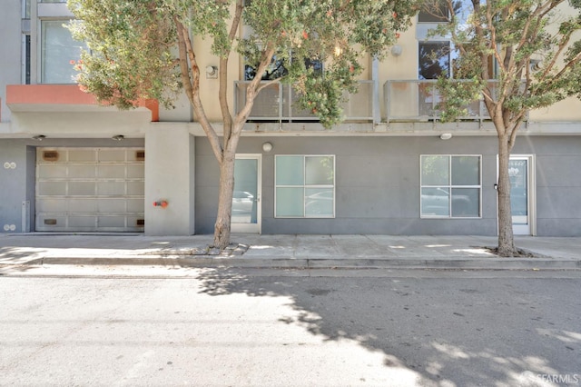 entrance to property with an attached garage and stucco siding