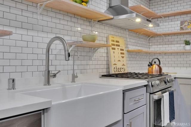 kitchen with open shelves, stainless steel gas stove, and a sink
