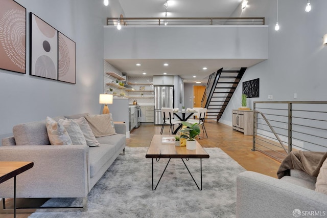 living area featuring a high ceiling and stairway