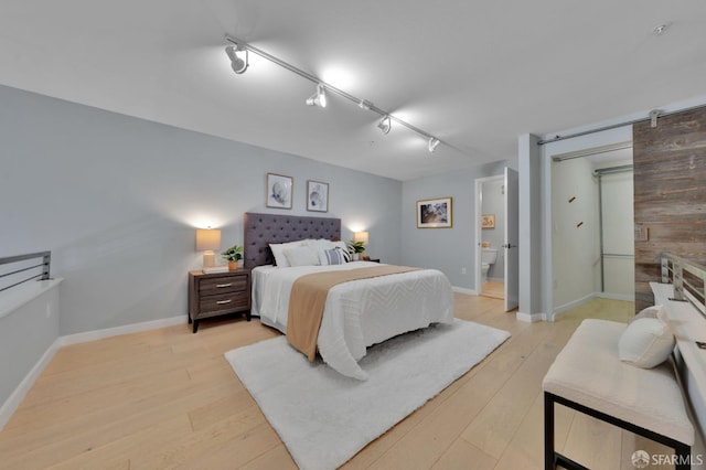 bedroom with light wood finished floors and baseboards