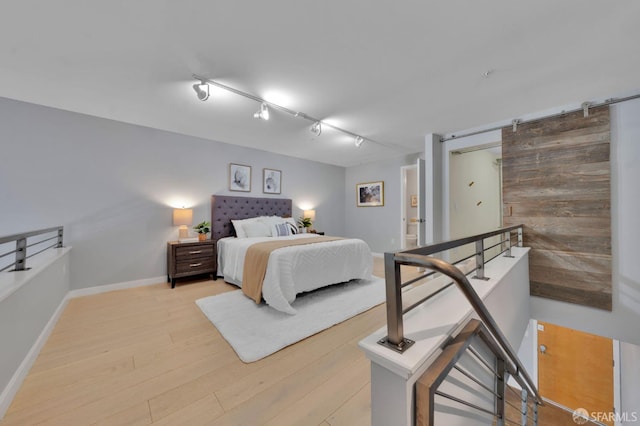 bedroom featuring light wood finished floors and baseboards