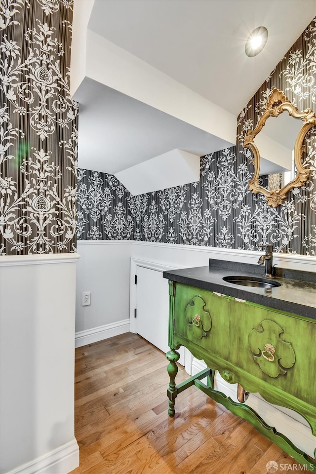 1258 York St, San Francisco, CA 94110 - bathroom with wallpapered walls, a wainscoted wall, wood finished floors, and vanity