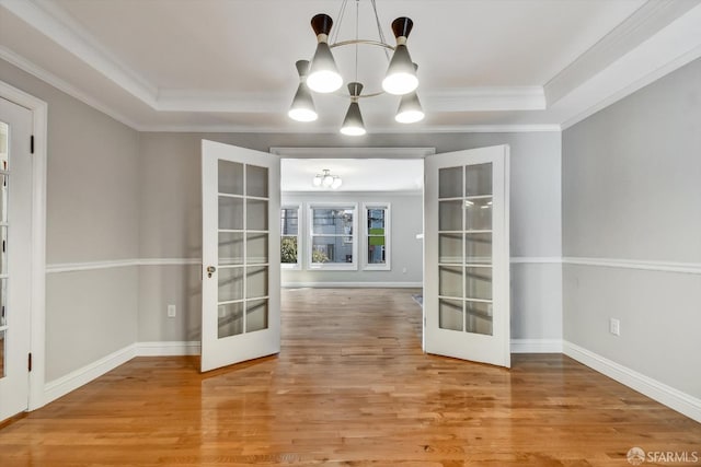 1258 York St, San Francisco, CA 94110 - empty room featuring french doors, a chandelier, wood finished floors, ornamental molding, and a raised ceiling