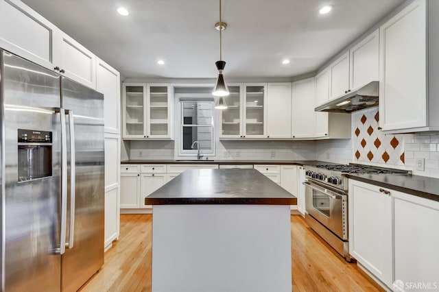1258 York St, San Francisco, CA 94110 - kitchen featuring stainless steel appliances, dark countertops, under cabinet range hood, light wood-type flooring, and recessed lighting
