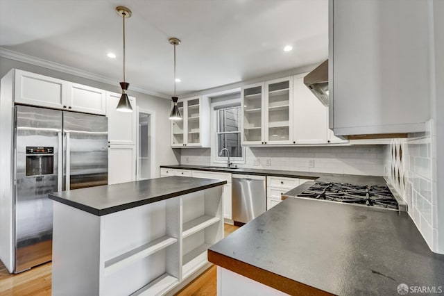 1258 York St, San Francisco, CA 94110 - kitchen with appliances with stainless steel finishes, dark countertops, ornamental molding, tasteful backsplash, and wall chimney exhaust hood