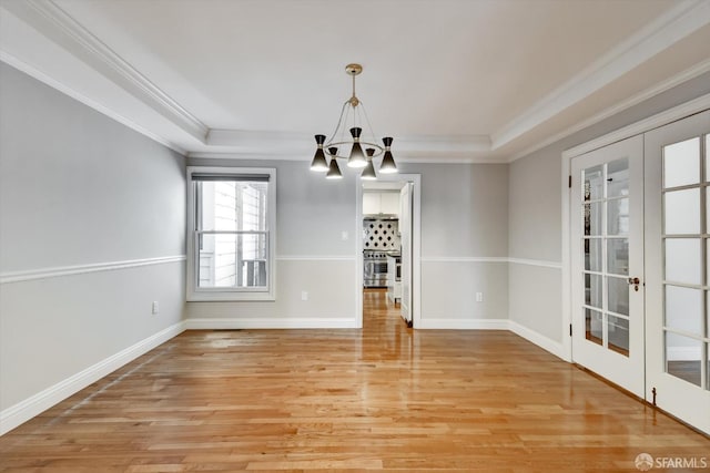 1258 York St, San Francisco, CA 94110 - unfurnished dining area featuring a chandelier, ornamental molding, light wood-style floors, a raised ceiling, and french doors