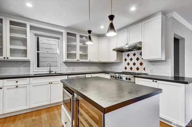 1258 York St, San Francisco, CA 94110 - kitchen with dark countertops, under cabinet range hood, range, white cabinetry, and recessed lighting