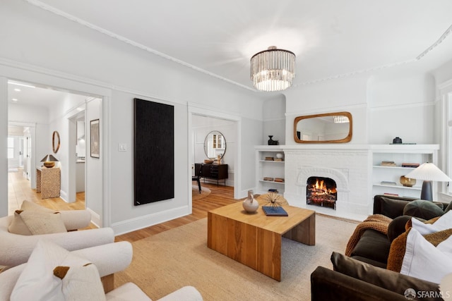 1980-1982 Fell St, San Francisco, CA 94117 - living area with light wood-style flooring, baseboards, built in shelves, a brick fireplace, and a chandelier