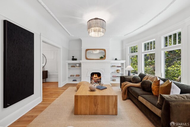 1980-1982 Fell St, San Francisco, CA 94117 - living area with a chandelier, light wood-style flooring, a brick fireplace, built in shelves, and baseboards