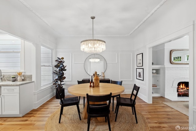 1980-1982 Fell St, San Francisco, CA 94117 - dining space with a decorative wall, a chandelier, light wood-style flooring, a brick fireplace, and built in features