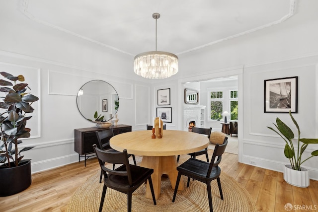 1980-1982 Fell St, San Francisco, CA 94117 - dining area with a decorative wall, a chandelier, light wood-style flooring, a lit fireplace, and ornamental molding