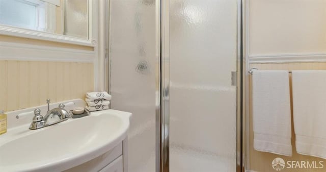 bathroom with a shower with door and sink