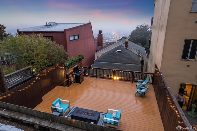 deck at dusk featuring an outdoor fire pit