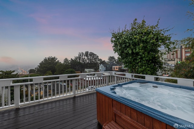 deck at dusk with a hot tub