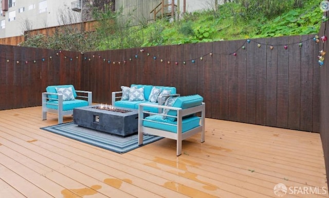 deck featuring an outdoor living space with a fire pit