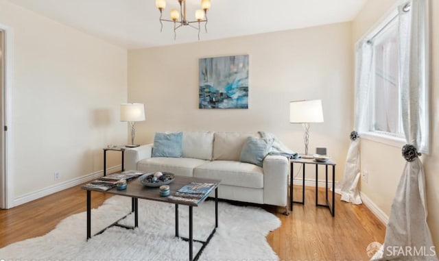 living room with an inviting chandelier and light hardwood / wood-style flooring