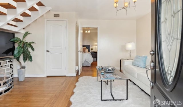 living room featuring wood-type flooring and an inviting chandelier