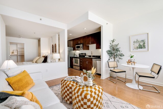 living room with sink and light hardwood / wood-style floors