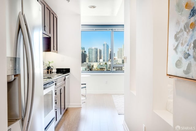 kitchen with stainless steel fridge, stove, and light hardwood / wood-style floors